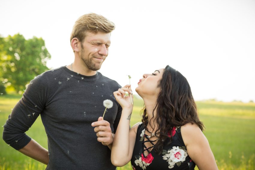 Cute couple blowing dandelions at each other